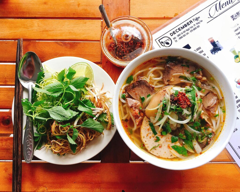 Top view of a delicious noodle soup with fresh herbs, perfect for a hearty meal.